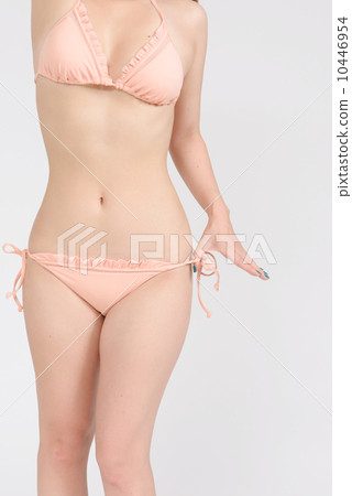 A rear view of a woman unwinding a swimsuit string 10446954