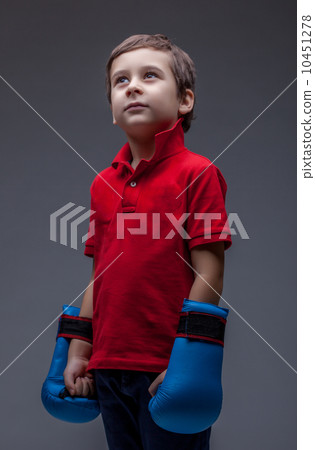 Thoughtful young boy posing in boxing gloves 10451278