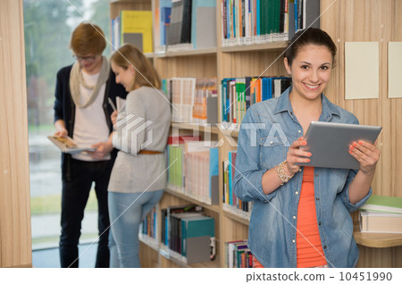 Student holding tablet in library Student holding tablet in library 10451990