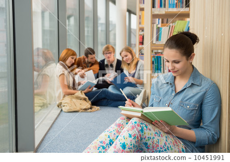 Student sitting in college library with friends 10451991