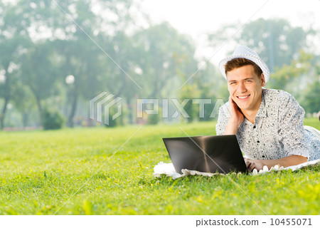 young man working in the park with a laptop young man working in the park with a laptop 10455071