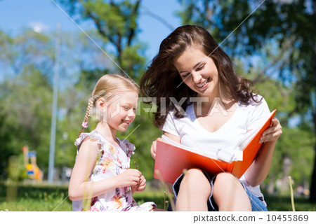 girl and a young woman reading a book together girl and a young woman reading a book together 10455869
