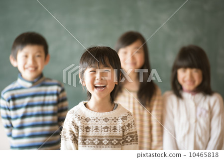 Elementary school student smiling in front of the blackboard 10465818