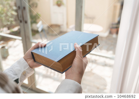 Hands of a woman reading a book by the window Hands of a woman reading a book by the window 10468692