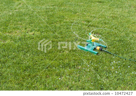 Lawn sprinkler over green grass 10472427