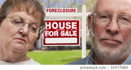 Depressed Senior Couple in Front of Foreclosure Sign and House Depressed Senior Couple in Front of Foreclosure Sign and House 10477060