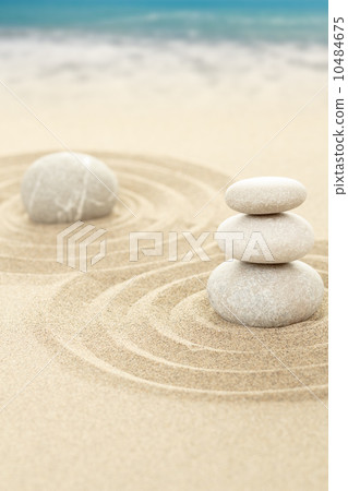 Balance zen stones in sand with sea in background Balance zen stones in sand with sea in background 10484675