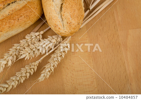 roll on wooden table with ears of wheat grain 10484857