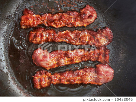 Bacon slice being cooked in frying pan 10488046