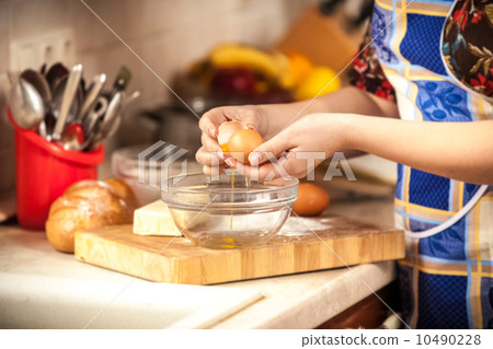 photo of woman breaking egg in glass bowl photo of woman breaking egg in glass bowl 10490228