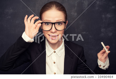 business woman teacher with glasses and a suit with chalk at a business woman teacher with glasses and a suit with chalk at a 10490464