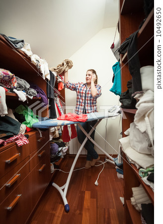 housewife looking at not ironed clothes at wardrobe housewife looking at not ironed clothes at wardrobe 10492650