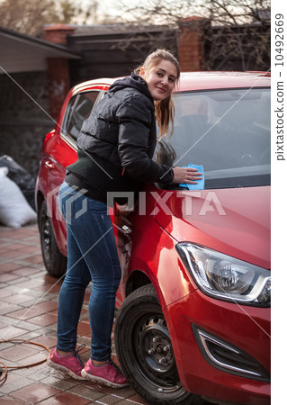 young woman washing red car 10492669