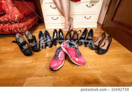female hand picking sneakers at wardrobe female hand picking sneakers at wardrobe 10492739