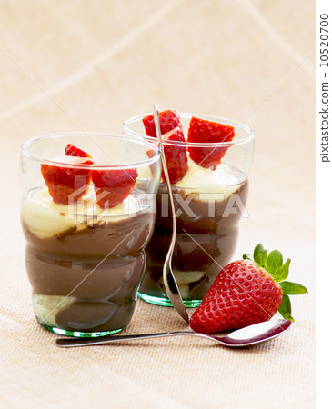 Two glasses with pudding, strawberry and teaspoons 10520700