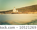 Christian Orthodox Church temple on icy lake with forest mountains on background Beautiful Landscape 10521269