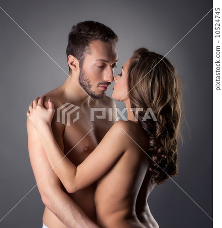 Passionate nude lovers embracing in studio 10524745