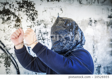 Hostage in handcuffs and with a bag on head near wall Hostage in handcuffs and with a bag on head near wall 10526935