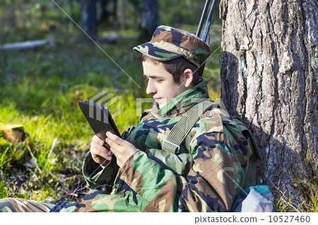 Recruit with tablet pc in forest near tree Recruit with tablet pc in forest near tree 10527460