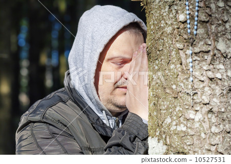 Religious man with a rosary near tree 10527531