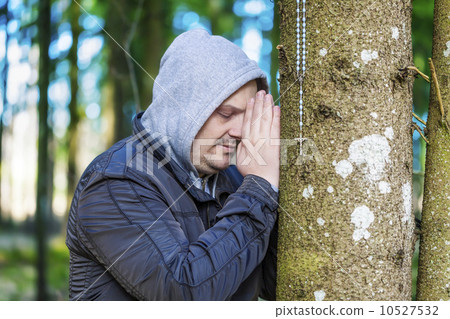 Religious man with a rosary in the woods 10527532
