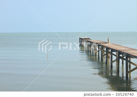 Wooden bridge into the sea 10529740