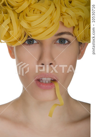 Woman holds in her mouth spiral noodles Woman holds in her mouth spiral noodles 10530716