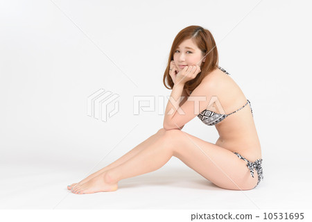 穿著坐和麵頰的泳裝的一名婦女 10531695