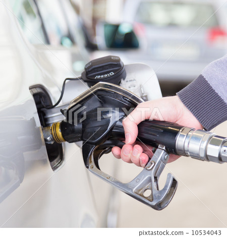 Petrol being pumped into a motor vehicle car. 10534043
