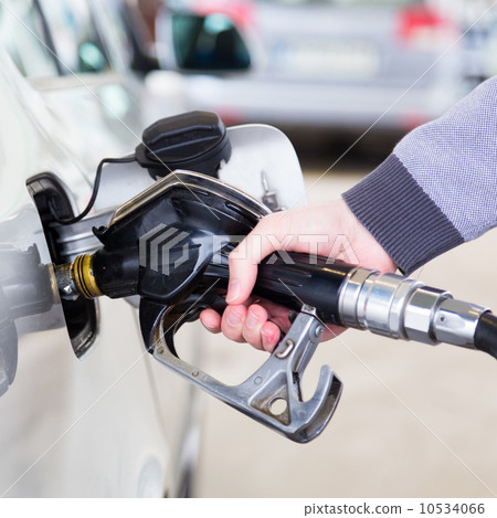 Petrol being pumped into a motor vehicle car. 10534066