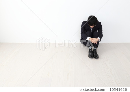 Male employee sitting holding a knee 10541626