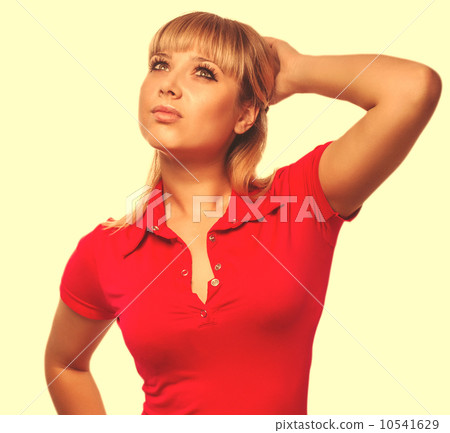 blonde woman looking up thinking thinking in a red vest and jean 10541629