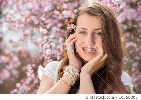 Romantic girl with braces near blossoming tree Romantic girl with braces near blossoming tree 10550803