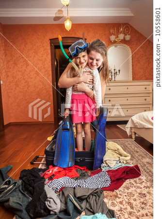 Woman embracing little girl in mask and snorkel in suitcase Woman embracing little girl in mask and snorkel in suitcase 10558601