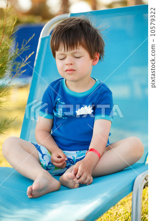 Cute toddler boy sitting on a sunbed Cute toddler boy sitting on a sunbed 10579322