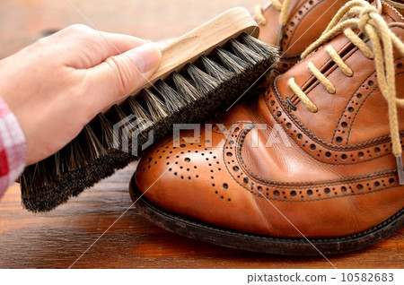 Image of shoes care. (Brushing with horse shoe brush) 10582683