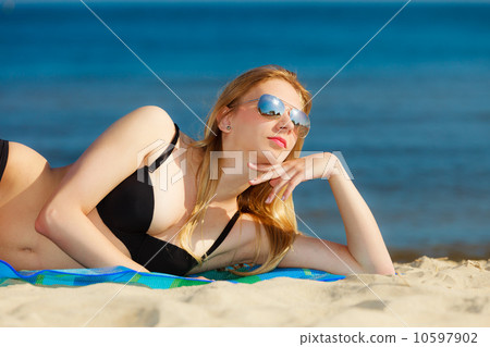 Summer vacation Girl in bikini sunbathing on beach Summer vacation Girl in bikini sunbathing on beach 10597902