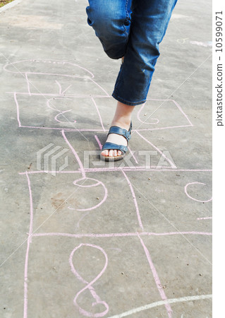 girl hops in hopscotch outdoors 10599071