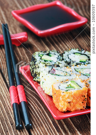 seafood rolls and chopsticks on a red plate seafood rolls and chopsticks on a red plate 10609397