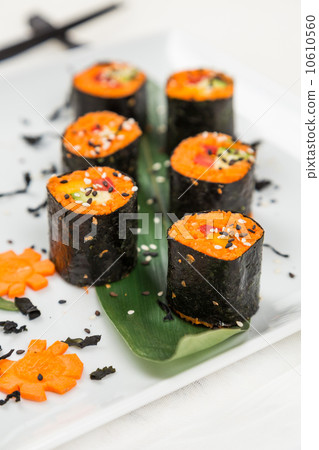 serving raw vegetarian rolls with carrot serving raw vegetarian rolls with carrot 10610560