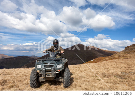 male rider sitting on ATV at mountain top 10611266