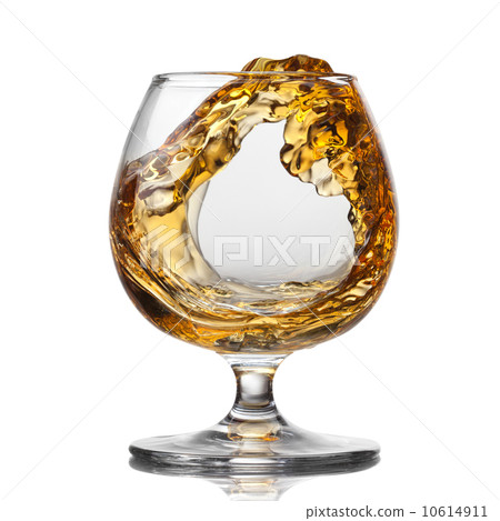 Splash of cognac in glass isolated 10614911
