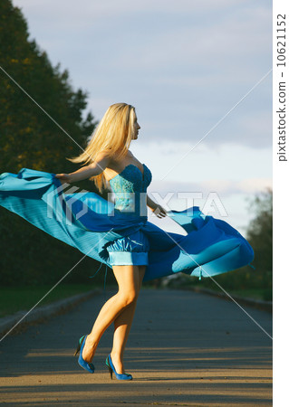 elegant woman in blue dress whirls and enjoying life in the park elegant woman in blue dress whirls and enjoying life in the park 10621152