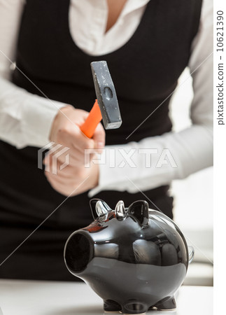 photo of woman smashing black piggy bank with hammer photo of woman smashing black piggy bank with hammer 10621390