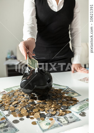 photo of woman inserting dollar in pig moneybox photo of woman inserting dollar in pig moneybox 10621391