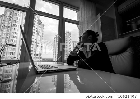 dreamy businesswoman looking out of window in office dreamy businesswoman looking out of window in office 10621408