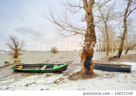 green boat on shore in winter 10655100