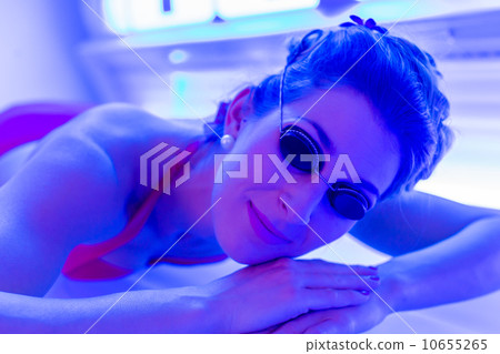 Woman in bikini tanning in wellness spa solarium 10655265