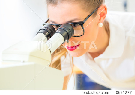 Orthodontist  working with microscope and grinder 10655277