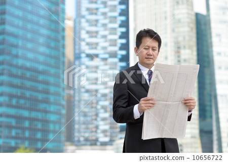 Successful entrepreneur stock agent business man reading newspaper in front of glass office building 10656722